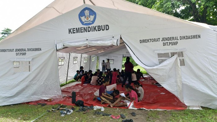 People who were evacuated from their homes due to the eruption of Mount Lewotobi Laki-Laki rest at a temporary shelter in Flores Timur, Indonesia, Monday, Jan. 15, 2024. Indonesia has evacuated thousands of people on the island of Flores after the volcano spewed thick clouds of brownish ash for the past days, authorities said on Monday. (AP Photo/Andre Kriting)