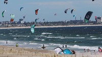 Orang-orang melakukan selancar layang di pantai Bloubergstrand di Cape Town, Afrika Selatan, Senin (15/1/2024).