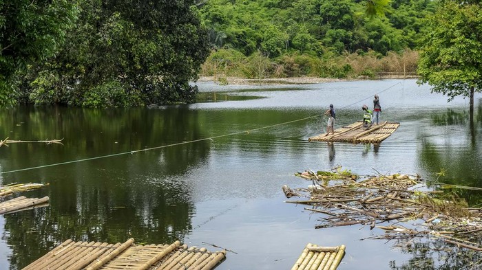 Pengendara roda dua menggunakan jasa perahu eretan saat menyeberangi Bendungan Karian di Cimarga, Lebak, Banten, Senin (15/1/2024). Warga di daerah tersebut yang hendak menuju Rangkasbitung dan Sajira lebih memilih menyeberangi Bendungan Karian dengan menyewa perahu eretan dengan tarif Rp10 ribu per sepeda motor sebagai jalur alternatif guna mempersingat waktu tempuh. ANTARA FOTO/Muhammad Bagus Khoirunas/nym.