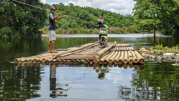 Pengendara roda dua menggunakan jasa perahu eretan saat menyeberangi Bendungan Karian di Cimarga, Lebak, Banten, Senin (15/1/2024). Warga di daerah tersebut yang hendak menuju Rangkasbitung dan Sajira lebih memilih menyeberangi Bendungan Karian dengan menyewa perahu eretan dengan tarif Rp10 ribu per sepeda motor sebagai jalur alternatif guna mempersingat waktu tempuh. ANTARA FOTO/Muhammad Bagus Khoirunas/nym.