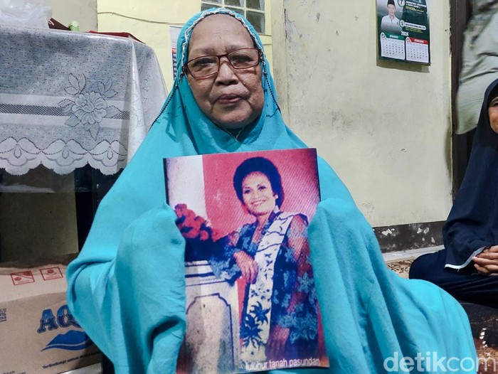Anak Iyar Wiarsih Memegang Foto Mendiang Ibunya