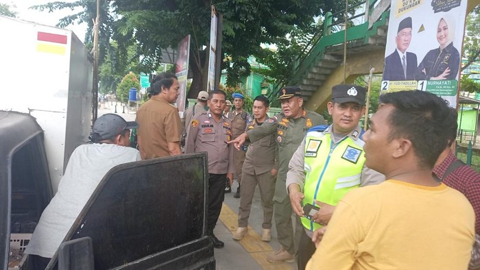 Anggota Satpol PP Palembang menertibkan PKL liar di Jalan Ahmad Yani Palembang.