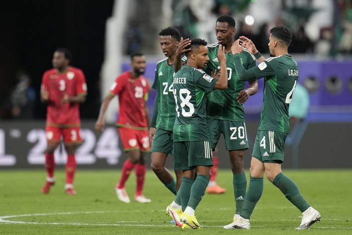 Saudi Arabias Abdulrahman Ghareeb, left, celebrates with teammates after scoring his sides first goal during the Asian Cup Group F soccer match between Saudi Arabia and Oman at Khalifa International Stadium in Doha, Qatar, Tuesday, Jan. 16, 2024. (AP Photo/Aijaz Rahi)