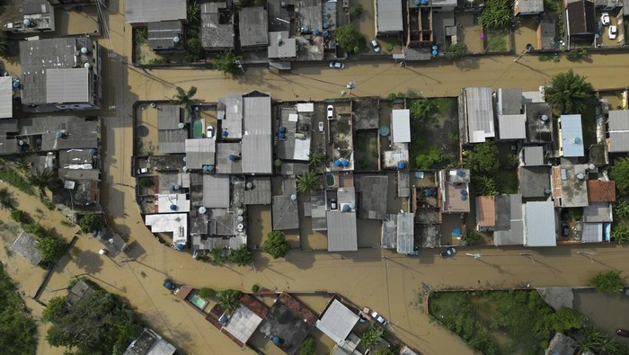 Brazil Floods Residents cross a submerged road by boat after deadly rainfall in Duque de Caxias, Brazil, Monday, Jan. 15, 2024. (AP Photo/Bruna Prado)