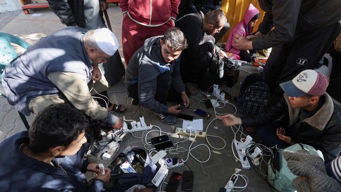 Cara Warga Gaza Mengisi Daya HP di Tengah Perang A child reacts as Palestinians charge their devices outside the Emirati hospital, amid the ongoing conflict between Israel and the Palestinian Islamist group Hamas, in Rafah in the southern Gaza Strip, January 15, 2024. REUTERS/Ibraheem Abu Mustafa