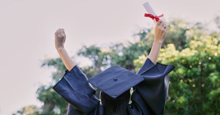 Graduation, education and success with a woman student holding a diploma or certificate in celebration outdoor. University, graduate and study with a female pupil cheering a college achievement