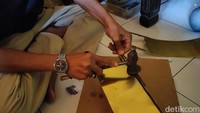 Imron saat membuat lentera dengan plat kuningan. Menurutnya membuat lentera membutuhkan ketelitian dan ketelatenan.