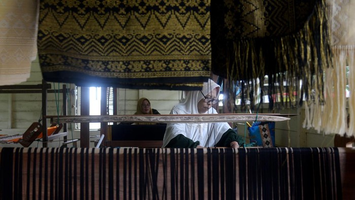 Melihat Pembuatan Songket Aceh yang Tembus Pasar Mancanegara Seorang perajin membuat kain songket khas Aceh di Rumah Tenun Songket Nyak Mu, Kabupaten Aceh Besar, Aceh, Rabu (17/1/2024). Songket khas Aceh dengan produksi terbatas karena menggunakan peralatan tradisional tersebut dijual dari harga Rp1,5 juta hingga Rp4 juta per lembar dan telah diekspor kesejumlah negara seperti Malaysia dan Singapura. ANTARA FOTO/Ampelsa/wpa.