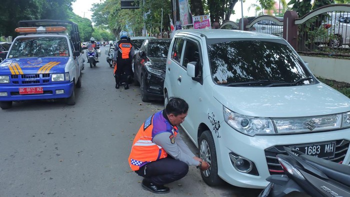 Petugas Diahub gembos ban yang parkir sembarangan.
