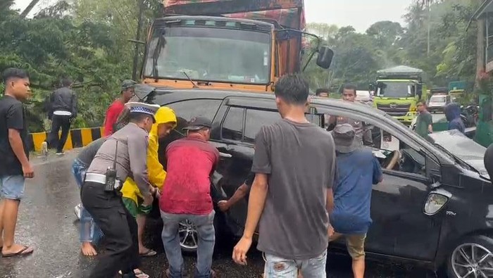Petugas kepolisian bersama warga hendak mengevakuasi salah satu mobil yang terlibat kecelakaan beruntn di Padang Panjang, Sumbar. (Dok. Humas Polres Padang Panjang)