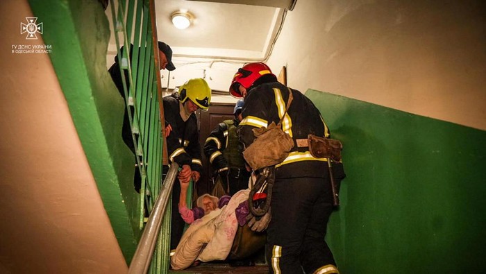 Serangan Rusia Hancurkan Apartemen dan Arena Bermain Anak di Odesa Rescuers evacuate a woman from a residential building damaged during a Russian drone strike, amid Russia's attack on Ukraine, in Odesa, Ukraine January 17, 2024. Press service of the State Emergency Service of Ukraine in Odesa region/Handout via REUTERS ATTENTION EDITORS - THIS IMAGE HAS BEEN SUPPLIED BY A THIRD PARTY.