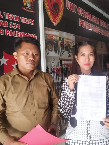 Kuasa hukum korban menunjukkan surat tanda terima laporan.