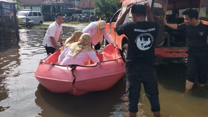 Tim BPBD saat membantu warga yang terdampak banjir
