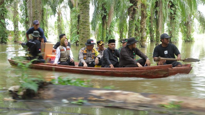 Kapolres Inhu dan rombongan naik perahu salurkan bantuan ke pengungsi banjir (Dok Polres Inhu)