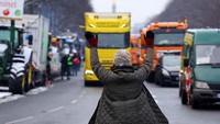 Seorang pengunjuk rasa menunjuk ke arah truk yang datang, saat pengemudi truk Jerman berdemo di Berlin, Jerman 18 Januari 2024.