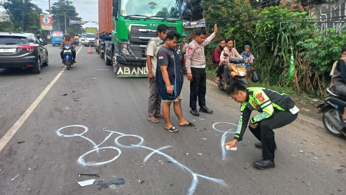 Polisi melakukan olah TKP kasus kecelakaan melibatkan truk dan motor yang menewaskan seorang PNS di Cileungsi, Kabupaten Bogor.