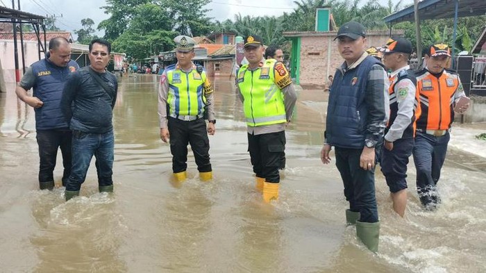 Polisi saat mengantut lalu lintas di jalan tergenang banjir meter, di Desa Kemang, Kecamatan Sanga Desa, Muba. Polisi saat mengantut lalu lintas di jalan tergenang banjir meter, di Desa Kemang, Kecamatan Sanga Desa, Muba.