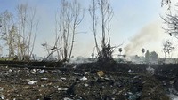 Puing-puing logam berserakan di tanah. Asap juga mengepul dari pabrik yang meledak. Samekan Suphan Buri Foundation via AP.