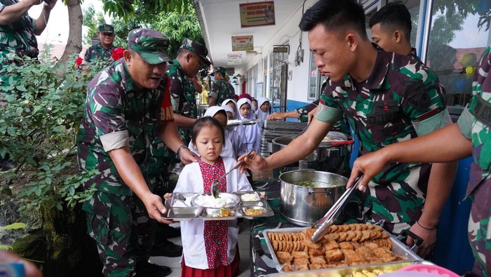 Anggota TNI Kodam II/Sriwijaya memberikan makanan nutrisi di SD N 39 Palembang
