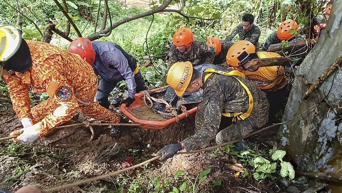 APTOPIX Philippines Landslide In this handout photo provided by the Municipality of Monkayo, rescuers retrieve a body of one of the victims after a landslide due to heavy rains at Monkayo town in Davao de Oro province, southern Philippines on Friday, Jan. 19, 2024. A landslide set off by days of heavy rain buried a house in the southern Philippines where people were holding Christian prayers, killing multiple people, including children, and seriously injuring some others, a disaster-response official said. (Municipality of Monkayo via AP)
