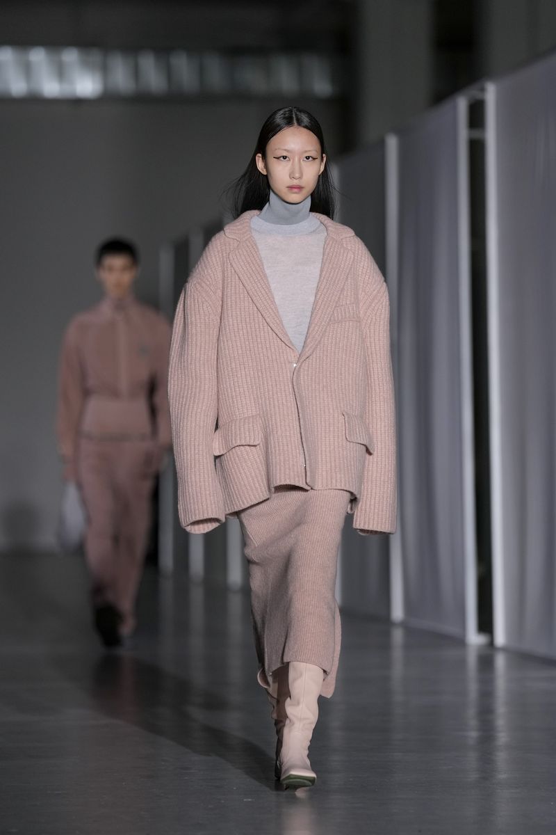 A model balances on top of another model wearing creations as part of the men's Federico Cina Fall-Winter 2024-2025 collection, that was presented in Milan, Italy, Saturday, Jan. 13, 2024. (AP Photo/Antonio Calanni).