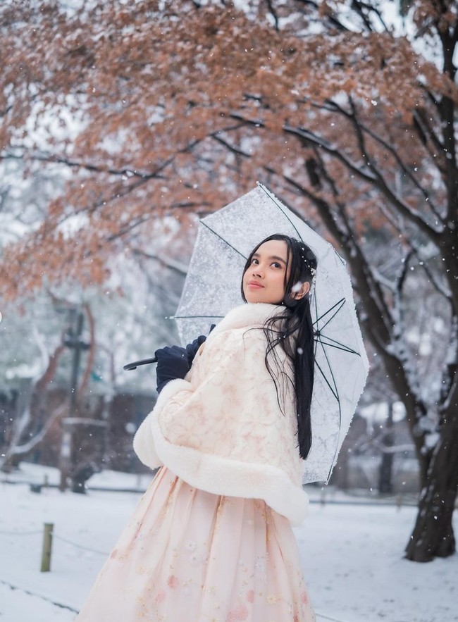 Seperti yang terlihat, pemotretan tersebut berlangsung ketika tengah turun hujan salju. Meski saat itu cuaca sedang dingin, namun Lyodra tampak begitu menikmati suasana dan pemandangan indah di sana. Foto: Instagram/@lyodraofficial