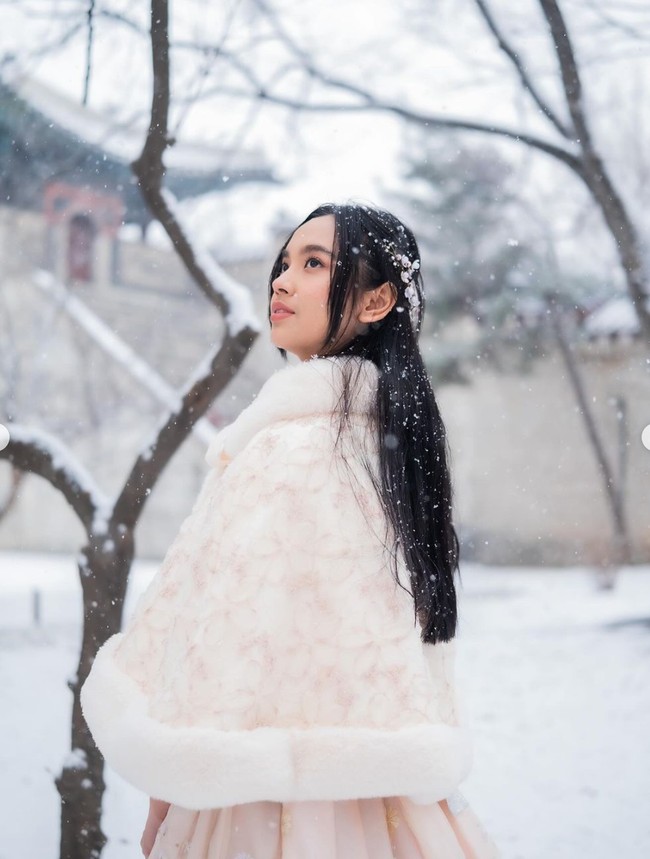 Sesuai dengan cuaca dingin di Korea, Lyodra tampak mengenakan Hanbok yang dilengkapi dengan mantel bulu berwarna salem. Rambut panjangnya tampak simpel dengan hanya diikat setengah dan menggunakan aksesori rambut. Foto: Instagram/@lyodraofficial
