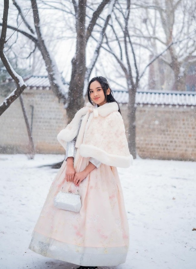 Hanbok yang dikenakan Lyodra itu tampak memiliki perpaduan warna salem dan silver. Penampilannya itu kemudian dilengkapi dengan tas kecil yang juga berwarna silver. Foto: Instagram/@lyodraofficial