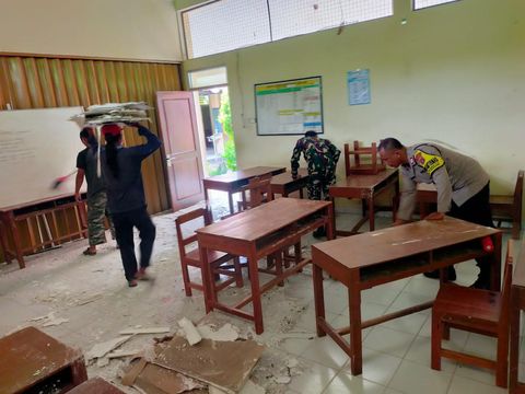 Petugas saat melakukan pembersihan reruntuhan plafon ruang kelas IV SDN Terban, Bambanglipuro, Bantul, Jumat (19/1/2024).