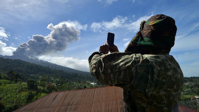 Status siaga darurat Gunung Marapi Petugas TNI memotret Gunung Marapi yang mengeluarkan abu vulkanik saat erupsi di Batang Silasiah, Nagari Bukik Batabuah, Agam, Sumatera Barat, Jumat (19/1/2024). Pemerintah setempat menetapkan status siaga darurat hingga 24 Januari 2024 agar bisa memaksimalkan penanganan warga yang berada di zona bahaya Gunung Marapi. ANTARA FOTO/Iggoy el Fitra/foc.