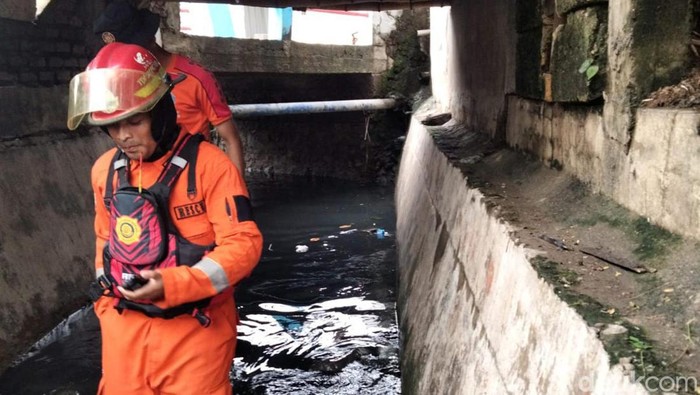 Tim SAR Gabungan melakukan pencarian anak yang diduga terperosok di selokan saat hujan-hujanan pada kemarin malam, Jumat (19/1/2023).