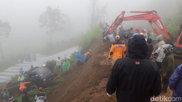 Warga bergotong-royong mengevakuasi mobil yang terjun ke ladang akibat keterjang tanah longsor di jalan Boyolali-Magelang di Selo.