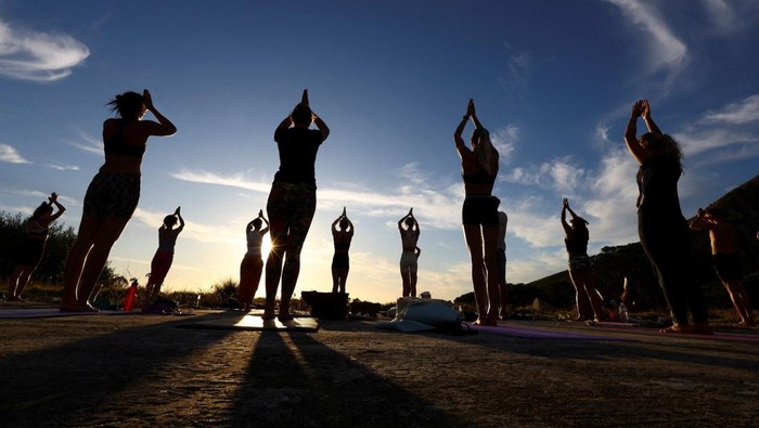 People perform yoga near Table Mountain in Cape Town, South Africa, January 18, 2024. REUTERS/Esa Alexander
