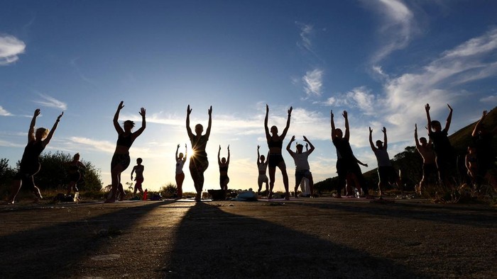 People perform yoga near Table Mountain in Cape Town, South Africa, January 18, 2024. REUTERS/Esa Alexander