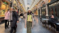 Foto ini memperlihatkan momen Iis Dahlia ketika liburan di Belgia. Ia berpose di depan restoran yang sajian waffle-nya dirindukan oleh Iis. Foto: Instagram @isdadahlia