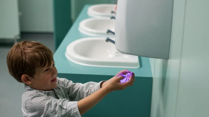 Ilustrasi mengeringkan tangan di alat pengering yang ternyata penuh bakteri, begini studinya.