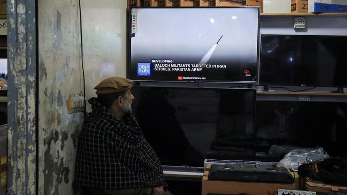 A man watches a news channel on television inside a shop after the Pakistani foreign ministry said the country conducted strikes inside Iran targeting separatist militants, two days after Tehran said it attacked Israel-linked militant bases inside Pakistani territory, in Peshawar, Pakistan January 18, 2024. REUTERS/Fayaz Aziz Acquire Licensing Rights