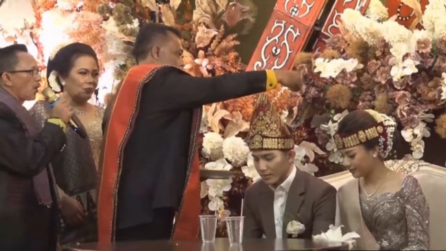 Anggi Marito dan Kenji Ganessha sebelumnya diketahui telah menggelar pemberkatan pernikahan pada 18 November 2023. Namun resepsinya yang mengusung adat Batak baru digelar pada Sabtu (20/1/24). Foto: YouTube/Kenjiro dan Anggi