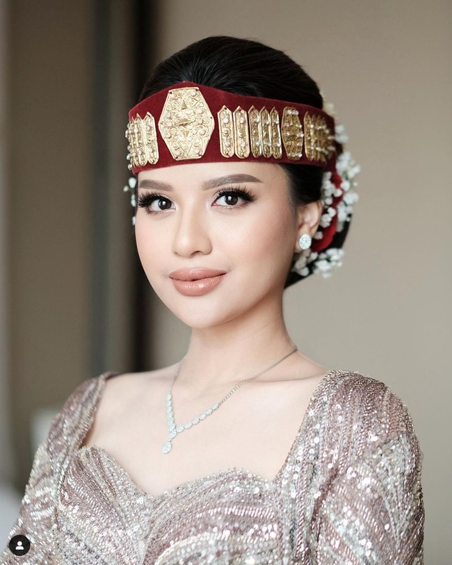 Di hari spesialnya itu Anggi tampil cantik mengenakan pakaian rancangan Christie Basil. Penampilannya semakin memukau dengan riasan wajah natural glam dan lipstik nude. Tak lupa Anggi juga mengenakan ikat kepala khas adat Batak atau Sortali. Foto: Instagram/@anggimarito