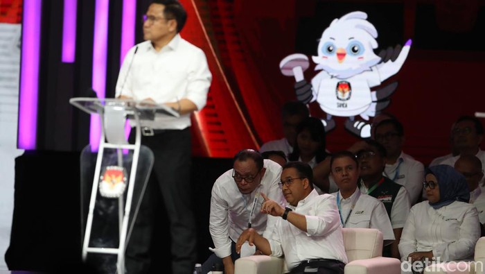 Anies Bisik-bisik ke Timnya Saat Debat Cawapres, Ada Apa? Anies Baswedan terlihat duduk di belakang Muhaimin Iskandar (Cak Imin) saat debat cawapres di JCC, Jakarta, Minggu (21/1/2024).