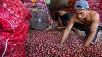 Pedagang mengupas kulit bawang merah yang akan dijual di Pusat Pasar, Medan, Sumatera Utara, Sabtu (20/1/2024).