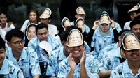Sebagian dari mereka memakai topeng bergambar capres yang didukungnya. 