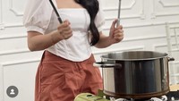 Tak hanya makan-makan, Putri Isnari juga sempat berpose sambil memegang spatula dan centongan nih. Pedangdut itu seperti sangat siap memasak bakso. Foto: Instagram @da4_putri03