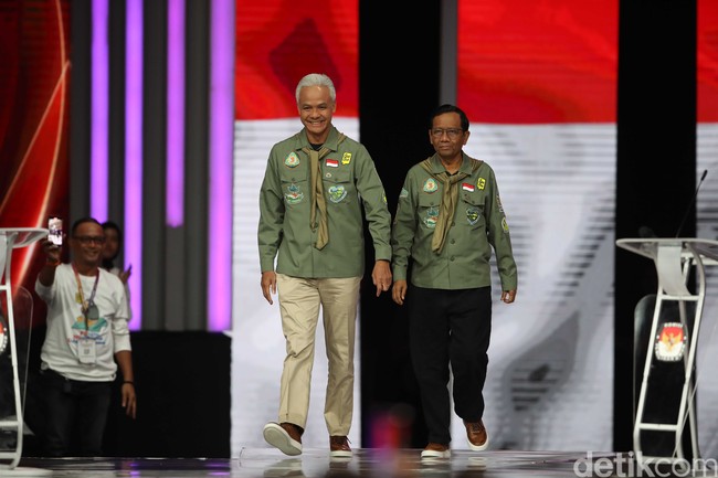 Momen debat keempat dimanfaatkan lagi oleh Ganjar-Mahfud untuk menunjukkan konsistensi mereka dalam menyesuaikan busana dengan tema. Menyambangi Posko Relawan Mahfud di kawasan Menteng sebelum bertolak ke lokasi debat, Mahfud MD memakai kemeja hijau lumut yang dihiasi patch atau tambalan bordir bertema lingkungan. (Foto: Pradita Utama/detikcom)