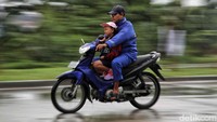 Pengendara melintas di Tanjung Priok, Jakarta Utara, saat hujan mengguyur kawasan tersebut, Minggu (21/1/2024).