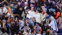 Warga tampak berdesakan dan berebut untuk bersalaman dan berfoto dengan Anies.