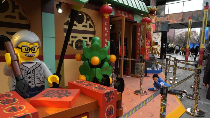 A man lifts a child on his shoulders near Chinese New Year themed decoration ahead of the upcoming Chinese Lunar New Year in Beijing, China on Saturday, Jan. 20, 2024. (AP Photo/Ng Han Guan)