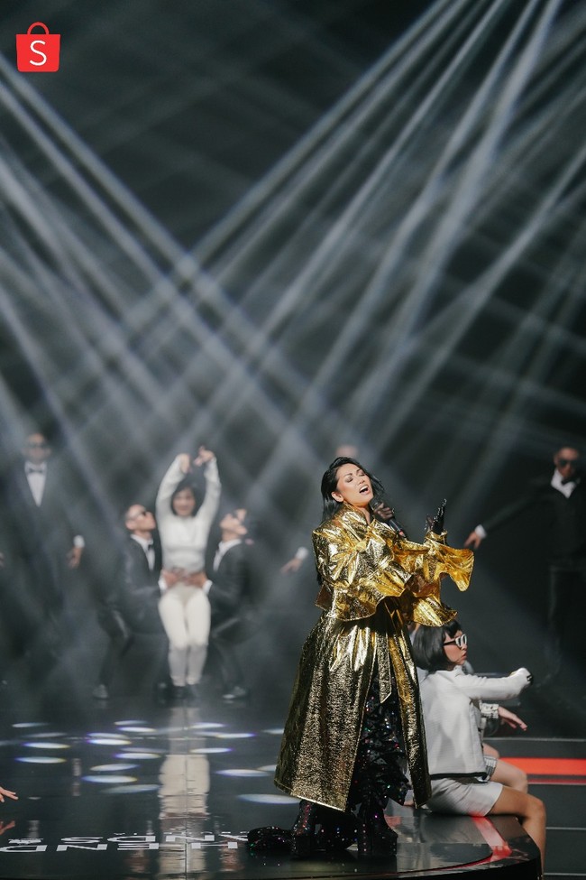 Anggun bergaya glamor sekaligus seksi mengenakan busana rancangan desainer Harry Halim. Jubah emas membuat penampilannya mencuri atensi. Foto: Dok. Shopee Indonesia