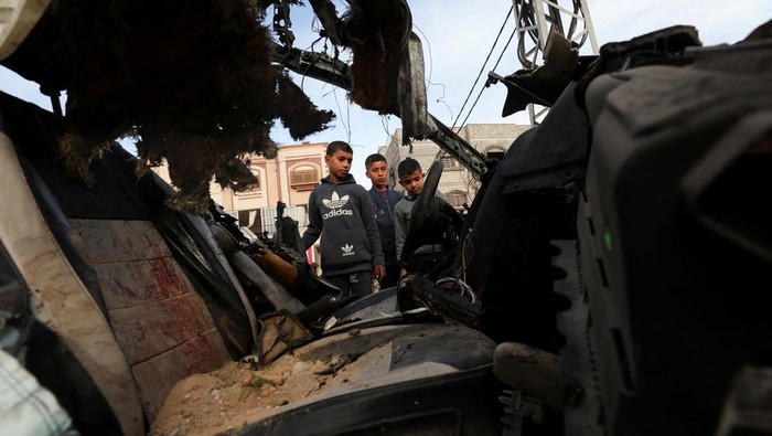 Mobil Dirudal Israel di Gaza, 4 Penumpangnya Tewas Mourners pray next to the dead bodies including four Palestinians killed in an Israeli strike on a car, amid the ongoing conflict between Israel and the Palestinian Islamist group Hamas, in Rafah in the southern Gaza Strip, January 21, 2024. REUTERS/Ibraheem Abu Mustafa REFILE - CORRECTING INFORMATION FROM