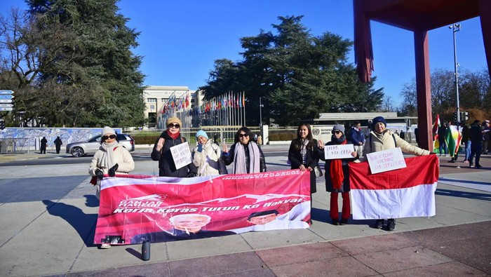 Ketua relawan Ganjarian Spartan Swiss, Usi Bo’i Nitha Müller Soplanit, dan penanggung jawab orasi Christiana Streiff, membentangkan spanduk bertuliskan dukungan kepada Ganjar Mahfud dan menolak Dinasti Politik di depan instalasi kursi patah di di depan kantor Perserikatan Bangsa- bangsa, Kota Jenewa, Swiss, Sabtu (20/1/2024).